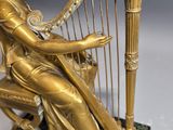 statue of a woman playing a harp on a marble base