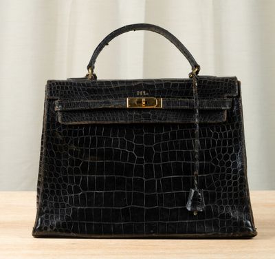 a close up of a black handbag on a wooden table