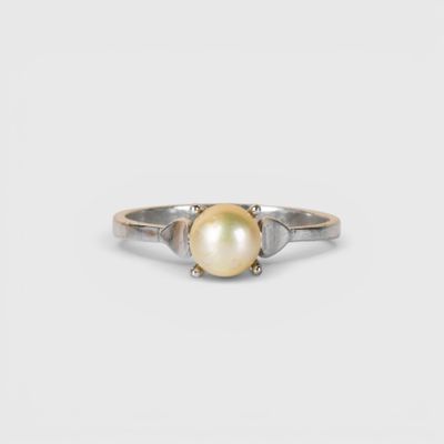 un gros plan d'une bague en perle sur fond blanc