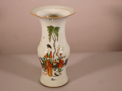 un vase blanc avec un tableau posé sur une table