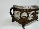 a glass bowl with a metal handle on a stand