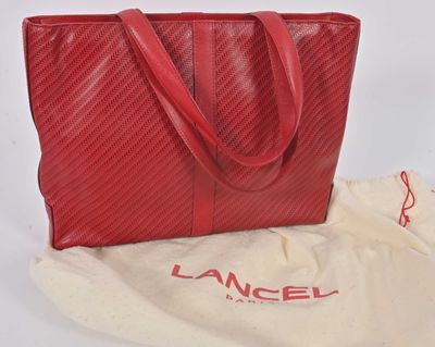 a red bag with a red handle sitting on top of a white bag
