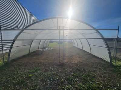 the sun shines brightly on the inside of a large greenhouse