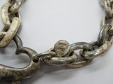 un gros plan d'une chaîne en argent ornée d'un crâne