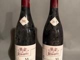 two bottles of wine sitting on top of a table next to each other
