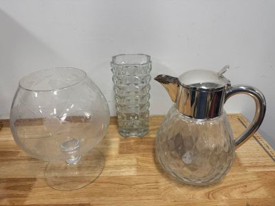three glass vases and a glass pitcher on a table