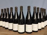 six bottles of wine are lined up in a row on a table