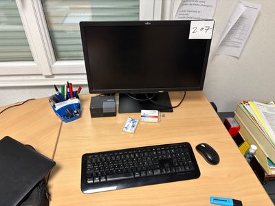 a computer desk with a keyboard, mouse, and a monitor