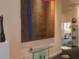 an image of a hallway with art on the wall and a glass table