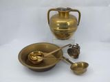 a gold vase and a bowl with spoons on a table