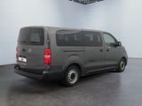 the back of a grey van parked in a large room