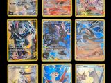 Les cartes Pokémon sont alignées sur une surface noire.