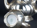 a silver tea pot and a silver tea pot on a table