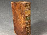 an old book sitting on top of a gray surface