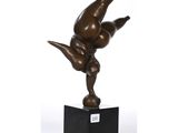 une statue en bronze représentant un homme faisant le poirier sur un socle