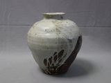 a white and brown vase sitting on a table