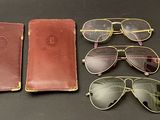 three pairs of sunglasses, a case and a pair of glasses