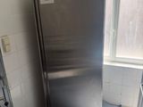 a stainless steel refrigerator in the corner of a kitchen