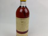 une bouteille de vin vide posée sur une surface blanche