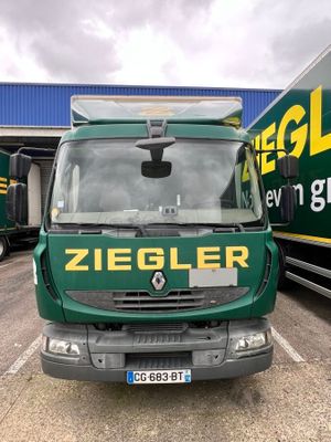 a green truck that is parked in a parking lot