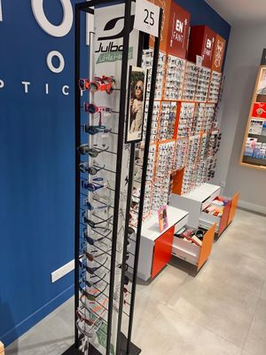 many glasses on display in a store with a blue wall