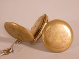 a gold pocket watch with a chain attached to it