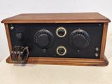 an old fashioned radio sitting on top of a table next to a pair of rings