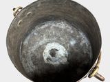 a large metal pot with a hole in the middle of it
