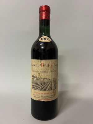 an old bottle of wine sitting on top of a white table