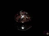 un vase en verre orné d'un anneau, posé sur une table