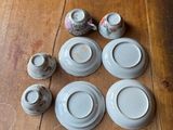 a wooden table with a bunch of plates and cups on it