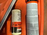 a can of paint and a canister of glue on the floor