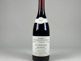 une bouteille de vin rouge posée sur une table blanche