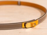 brown leather belt with gold buckle on a wooden surface
