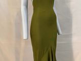 the dress is green and has a high neck and a ruffled skirt