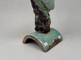 sculpture of a bird perched on top of a book on a white surface