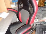 une chaise de bureau noire et rouge placée dans une pièce