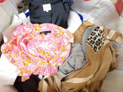 a pile of clothes sitting on top of a bed