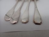 four spoons and a fork on a white table