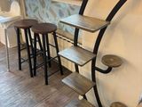 tables and stools in front of a window in a coffee shop