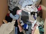 a cardboard box full of clothes that is sitting on the floor
