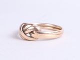 an image of a gold ring with a knot in the middle
