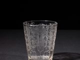 a close up of a glass on a table with a black background