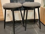 deux tabourets placés l'un à côté de l'autre sur un sol carrelé