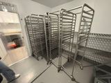 many racks of food in a kitchen with a person walking by