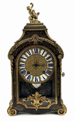 a gold clock with blue and white roman numerals on it