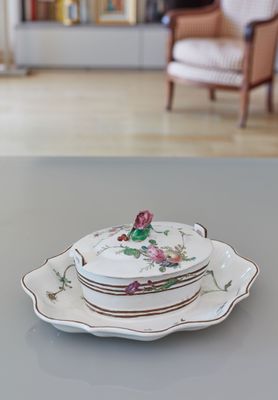 a stack of plates sitting on a table with a chair in the background