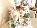a figurine of a woman sitting on a chair