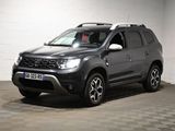 La Dacia grise est garée dans un garage dont le sol est en damier.
