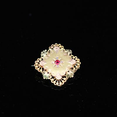 une image représentant une broche en or ornée de pierres roses et vertes